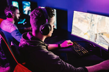 A professional gamer playing fist person shutter game in gaming room.