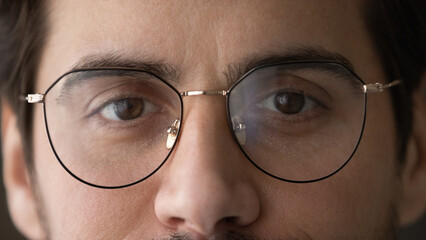 Solving vision problem. Close up cropped portrait of young man having eye astigmatism myopia short or long sight wear stylish glasses look at camera. Optical store ophthalmology clinic advertisement