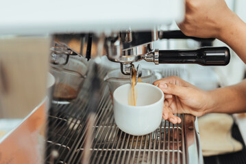Close-up of barista hands to making coffee with coffee machine. Coffee owner concept.