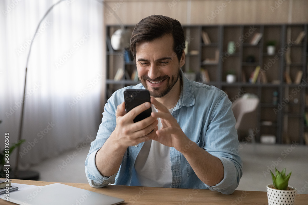 Wall mural pleasant phone communication. smiling millennial casual man use mobile telephone web app enjoy conve
