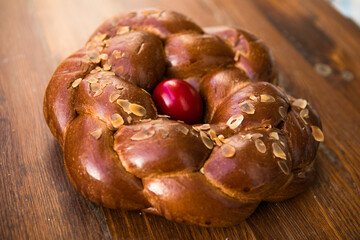 Tsoureki traditional baked Greek Easter sweet bread, garnished with slivered almonds and decorated with a boiled red dyed egg in the middle