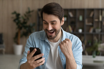 Oh yeah. Euphoric bearded male look at cell screen open mouth read exciting great news receive...