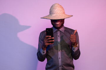 african man holding his phone, does thumbs up gesture