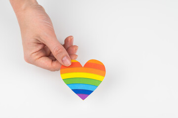 Female hands with rainbow paper heart isolated on white background. 