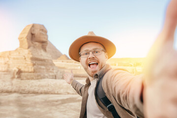 Travel Selfie photo man in hat background pyramid of Egyptian Giza and Sphinx, sunset Cairo, Egyp