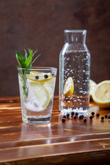 acqua in bicchiere con limone ed erbe aromatiche