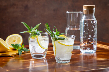 acqua in bicchiere con limone ed erbe aromatiche