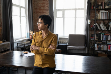 Serious pensive confident African businesswoman professional skilled specialist office employee pose alone in office staring aside looks thoughtful. Leadership, ponder ideas, business vision concept