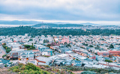 Fototapeta na wymiar San Francisco, California, USA - October 5, 2021, Evening view of the city from the top of San Francisco's Grandview Park next to the 16th Avenue tiled steps. Photo edited in pastel colors.