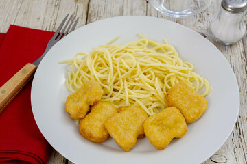 top view of a plate of spaghetti with chicken nuggets