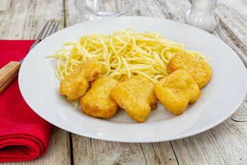 plate of spaghetti with chicken nuggets