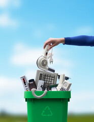 Woman putting an old appliance in the waste bin