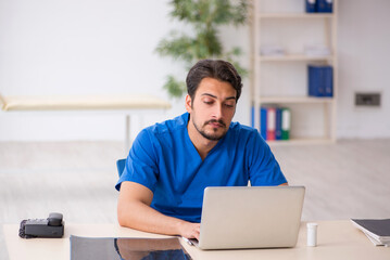 Fototapeta premium Young male doctor in telemedicine concept
