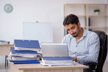 Young male employee and too much work in the office