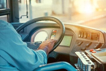 Hands of driver in a modern bus by driving. Close-up of bus driver steering wheel and driving...