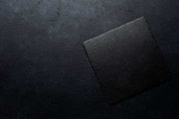Black painted concrete texture or background and slate board with shadow.and with place for text. Template for design