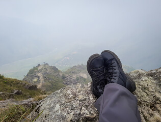 hiker foot resting at mountain top from flat angle at morning