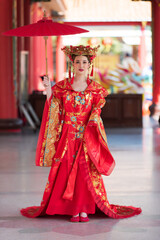 portrait of a woman. person in traditional costume. woman in traditional costume. Beautiful young woman in a bright red dress and a crown of Chinese Queen posing 