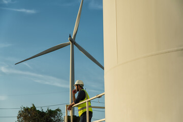 portrait of engineer using radio communication on wind turbine on background. engineer with turbine