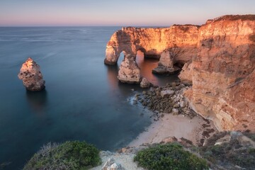 Fototapeta na wymiar Natural arch above ocean. Natural caves at Marinha beach, Algarve, Lagoa portugal. Stone arch at beach. Summer season.