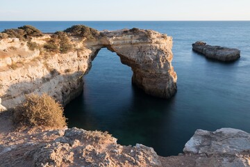 Natural arch above ocean, arco de Albandeira, Algarve, Lagoa portugal. Stone arch at beach.
Summer season.