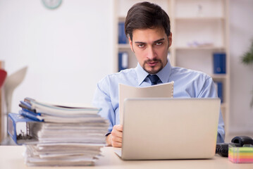 Young male employee and too much work in the office