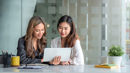 Two young Asian business woman talk, consult, discuss working with new startup project idea...