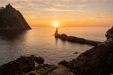 Fototapeta na wymiar Orange sunset at the Lighthouse of the bay of Pasaia in the town of San Juan. Gipuzkoa. Basque Country