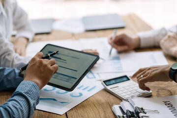 Business people discuss investment project working and planning strategy on digital tablet. Business people talking together with tablet at office.