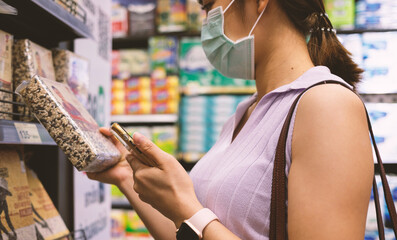 Woman wearing protective mask on her face while using cell phone and shopping purchase healthy...