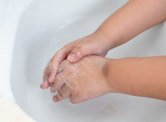 Children wash their hands with hand soap to prevent infection and viruses