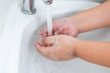 Fototapeta premium Children wash their hands with hand soap to prevent infection and viruses