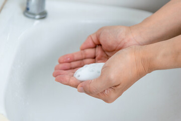 adults wash their hands with hand soap to prevent infection and viruses