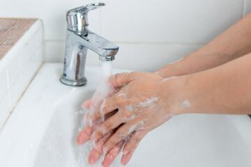 adults wash their hands with hand soap to prevent infection and viruses