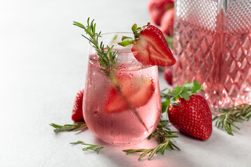 Refreshing drink with natural ice, strawberries, and rosemary. - obrazy, fototapety, plakaty