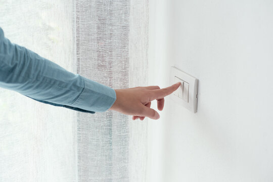 Woman pressing a light switch