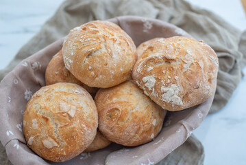 Bread basket, round bread rolls on dark table