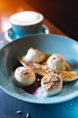 fresh coffee and cheese pancakes with banana, mango and berry sauce