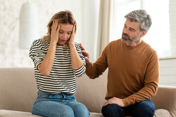 Wife Suffering From Headache, Husband Caring For Her At Home