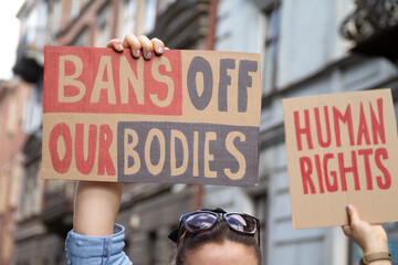 Protesters holding signs Bans Off Our Bodies and Human rights. People with placards supporting abortion rights at protest rally demonstration. - obrazy, fototapety, plakaty