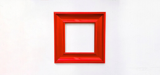 Red empty picture frame isolated on white wall with copy space. Object on concrete wallpaper for...
