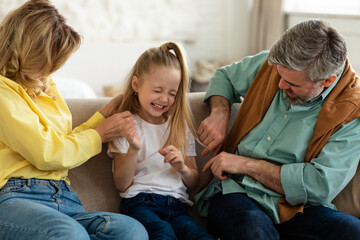 Cheerful Family Playing Having Fun, Parents Tickling Daughter Indoor