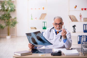 Old male doctor radiologist working in the clinic