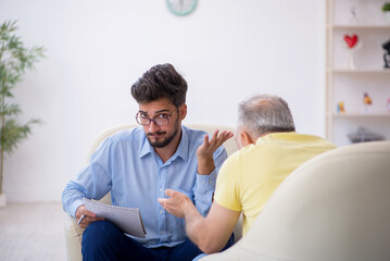 Old man visiting young male psychotherapist