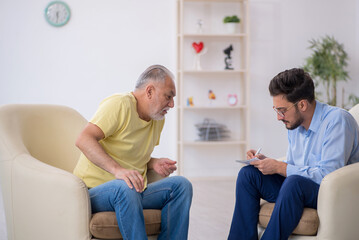 Old man visiting young male psychotherapist