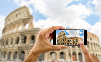 tourist takes a picture with his mobile of coliseum in Rome in Italy