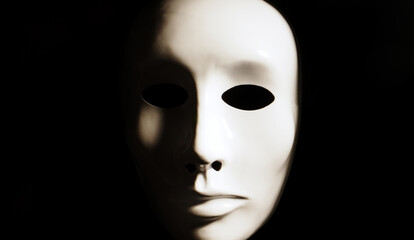 White face mask on dark background.