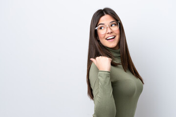 Young Brazilian woman isolated on white background pointing to the side to present a product