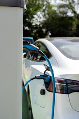 Electric car charging at plug in charge station in a public car park in Suffolk, UK