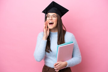 Young student Brazilian woman wearing graduated hat isolated on pink background shouting with mouth wide open to the side